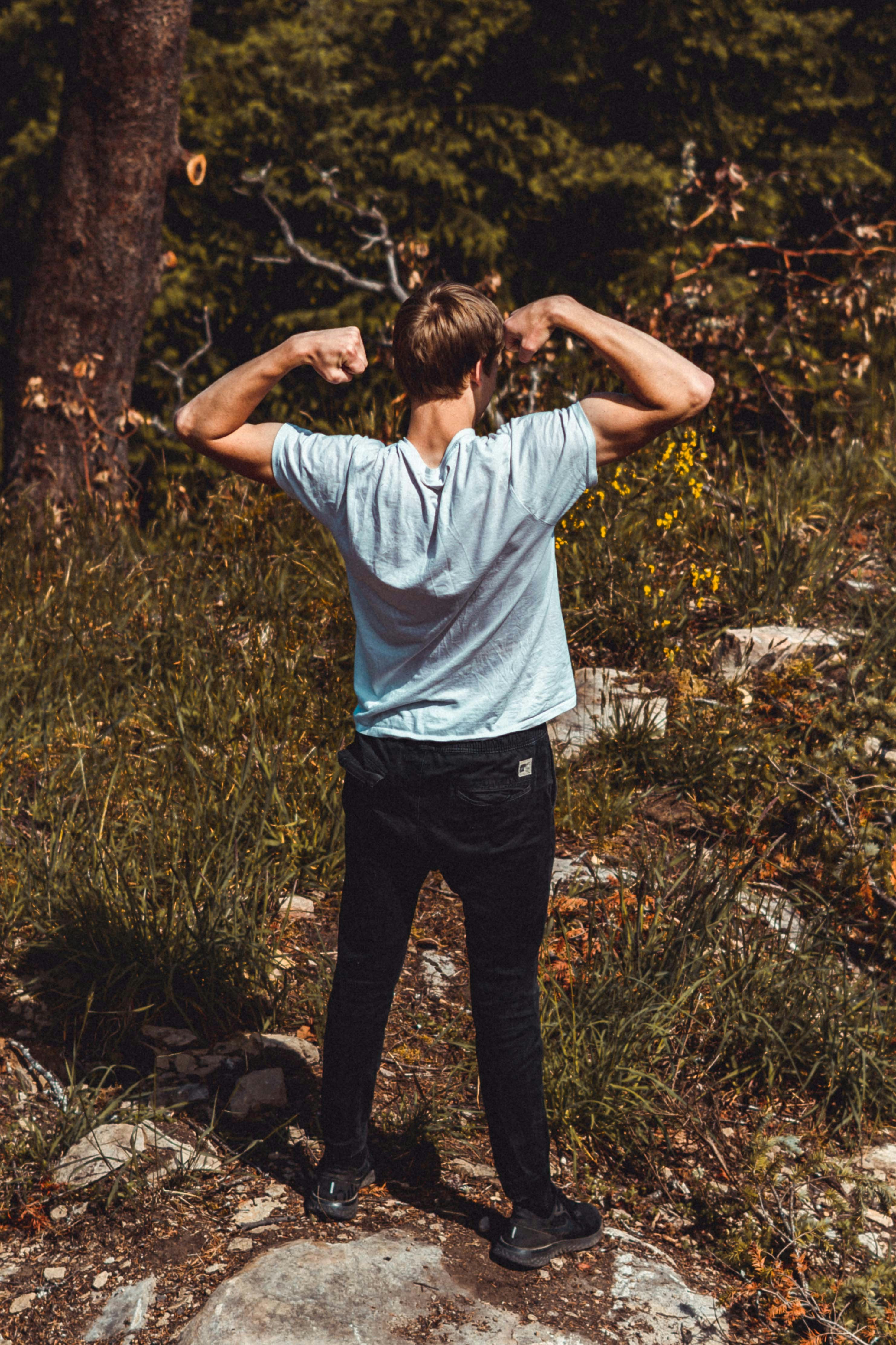 man in white shirt and black pants standing on green grass field